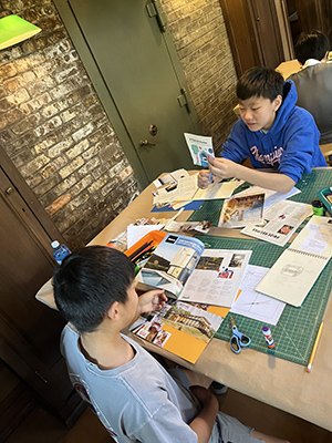 Two middle school campers create vision board collages as they plan their models