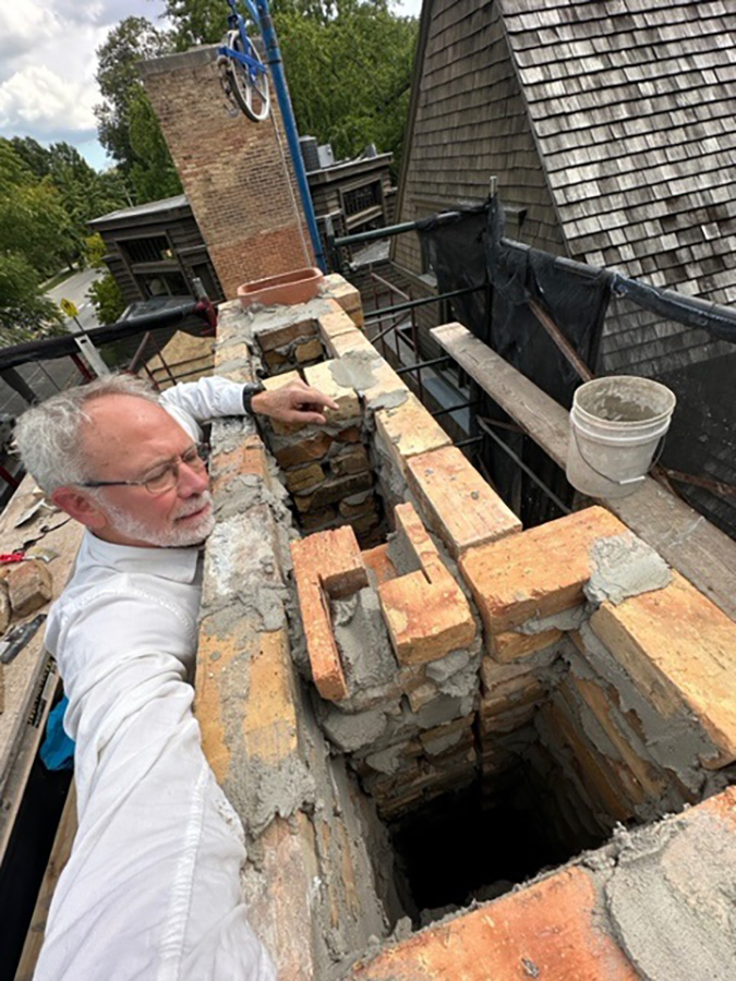 Doug Freerksen, founding partner and president of Von-Dreele Freerksen Construction Co. inspects a rebuilt chimney flue.