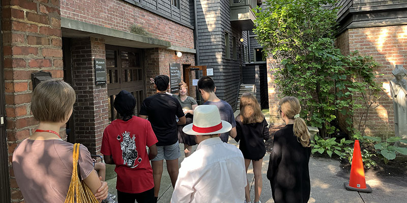 Campers listen to a short lecture about adaptive reuse outside of the garage- turned-giftshop at the Home and Studio.