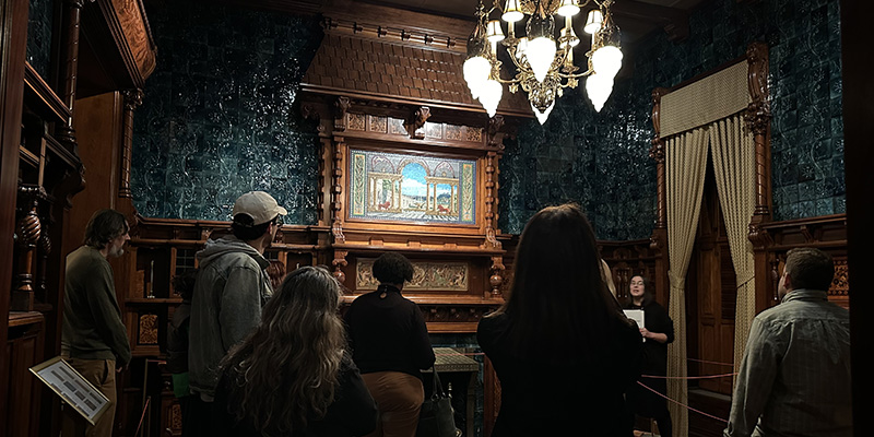 A few educators listen to docents at the Driehaus Museum and compare the architectural styles of Wright and the gilded age Nickerson Mansion. The Driehaus hosted Evenings for Educators in collaboration with the Frank Lloyd Wright Trust during the exhibition Photographing Frank Lloyd Wright.
