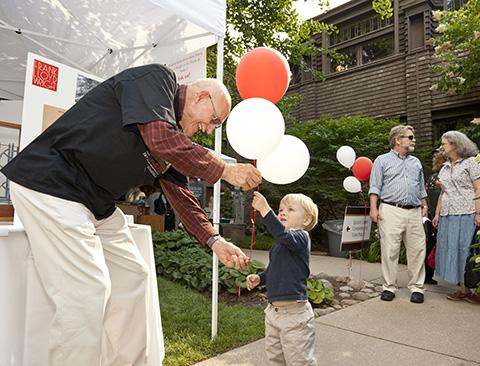 person giving balloons to child
